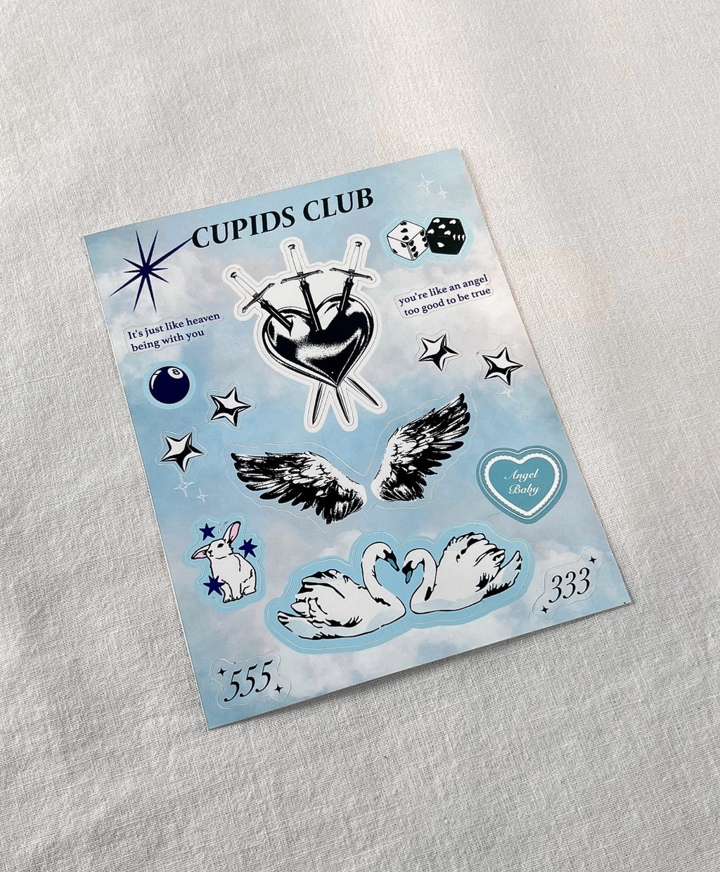 Angel Baby sticker sheet with Three of Swords tarot, angel wings, swans, and pastel cloud background.