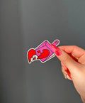 Broken Hearts Sticker next to a hand for size comparison