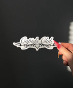 Cupids Club Sticker in Black next to a hand for size comparison