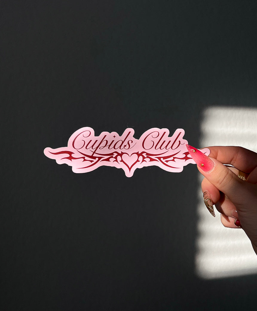 Cupids Club Sticker in Pink next to a hand for size comparison