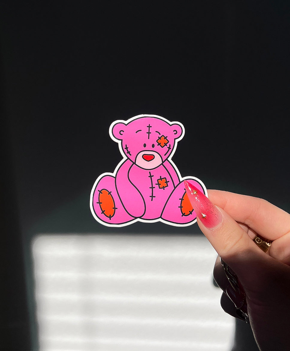 Cutie Bear Sticker in sunlight next to a hand for size comparison