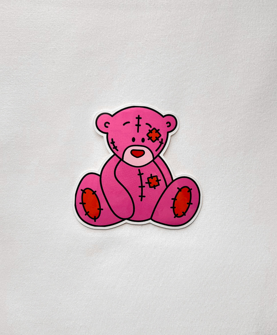 Cutie Bear Vinyl Sticker featuring a sad pink teddy bear with patches