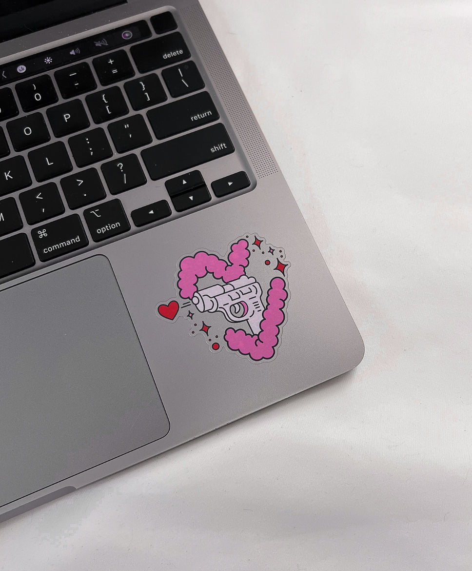 Love Gun Sticker with a transparent background on a laptop computer for size comparison
