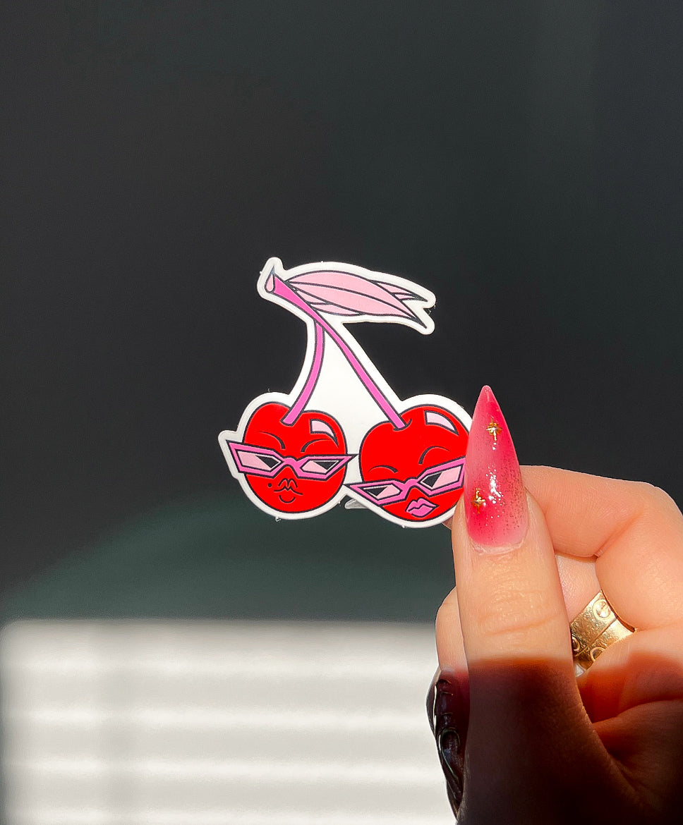 Sunny Cherry Sticker in sunlight next to a hand for size comparison