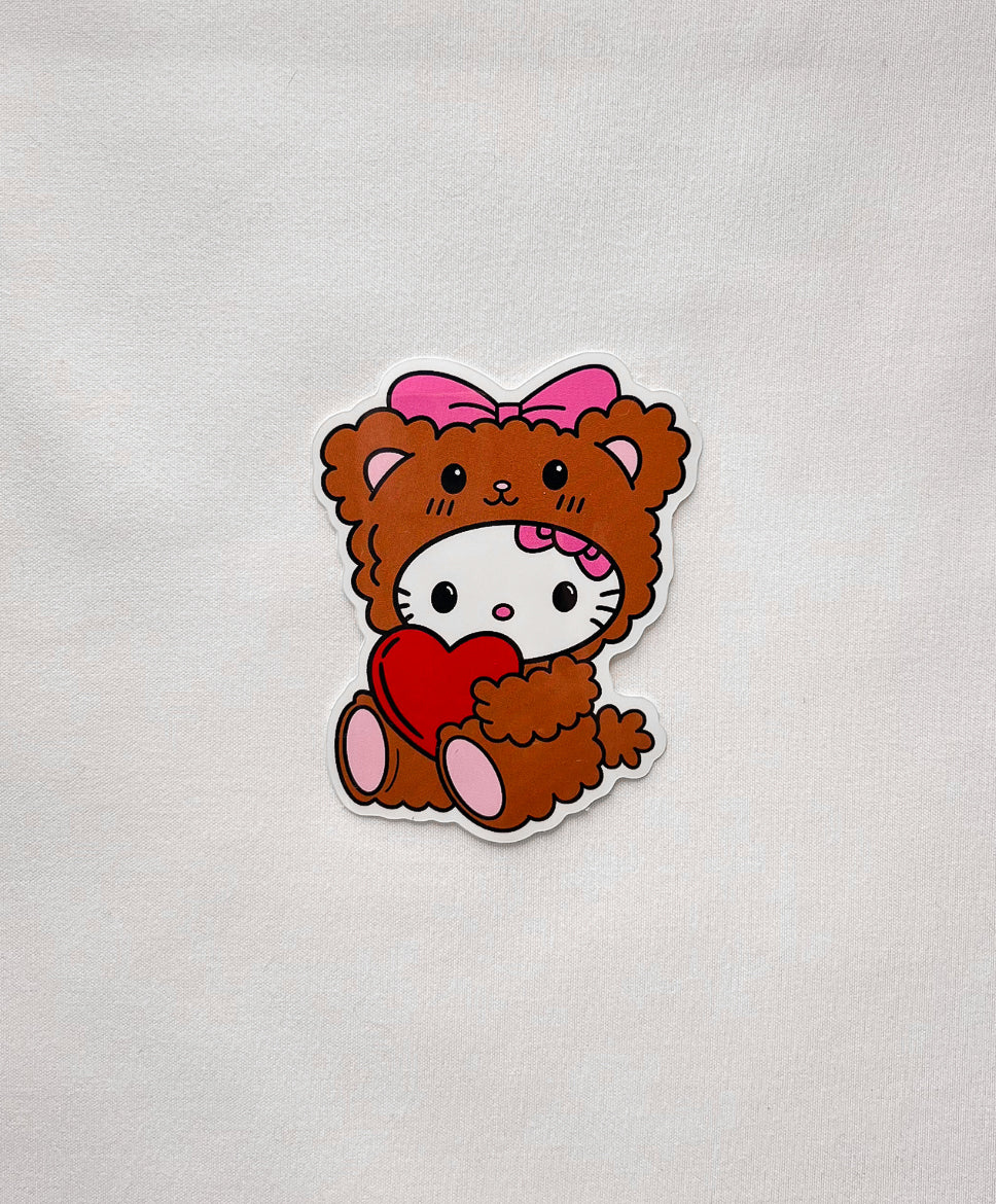 Teddy Bear Kitty Sticker features a cute white kitty in teddy bear costume with a red heart and pink bow