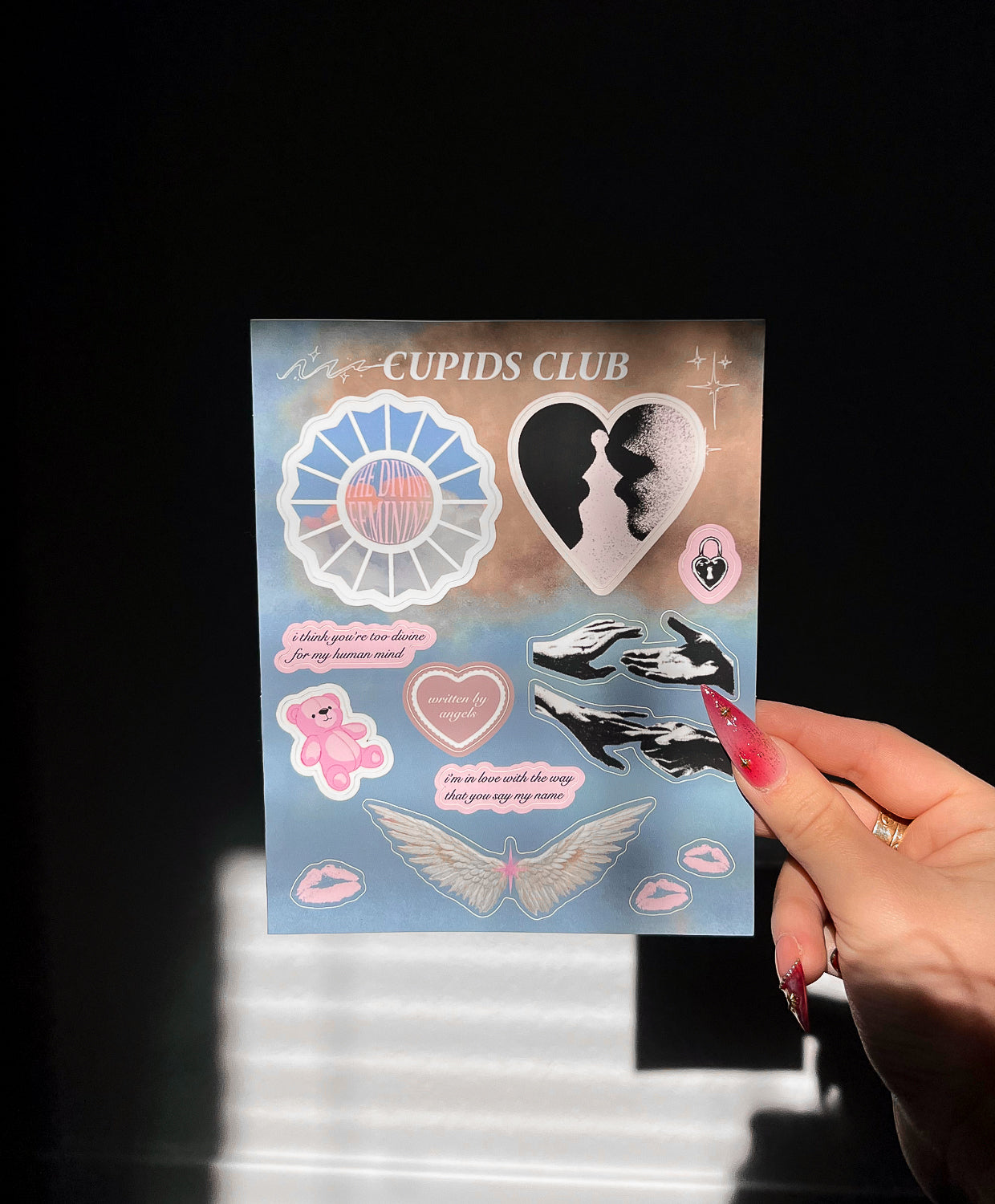 Straight view of Divine Feminine stickers in sunlight next to a hand for size comparison